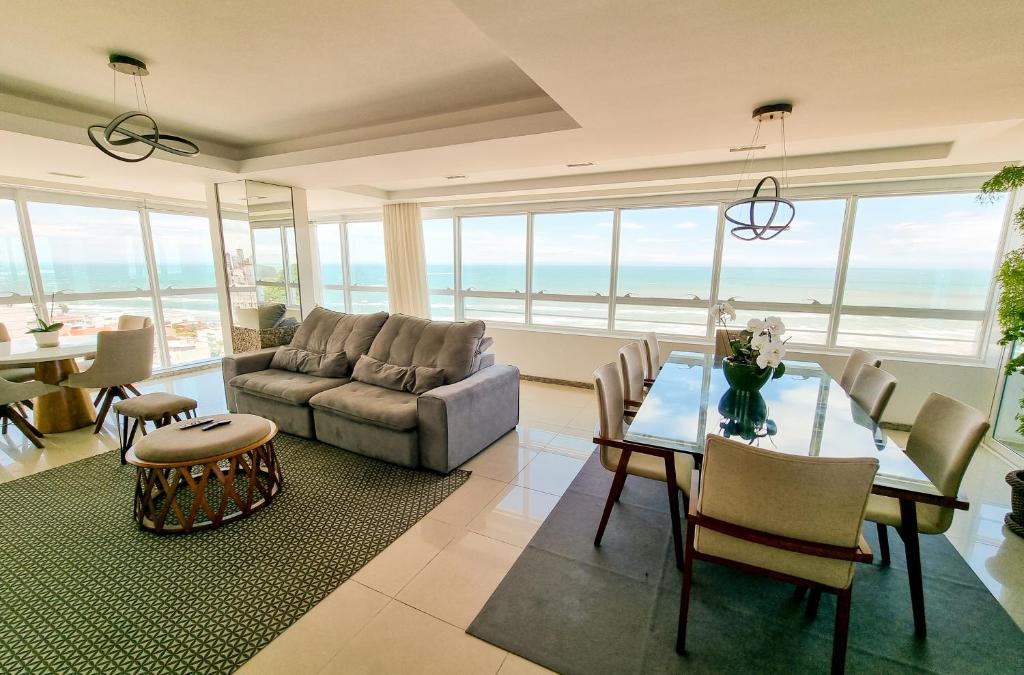 a living room with a couch and a table and chairs at Apartamento espetacular, melhor vista e localização de Torres in Torres