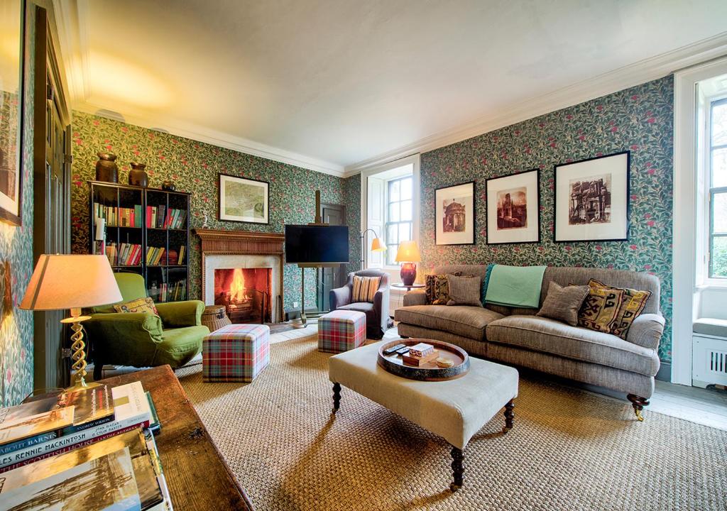 a living room with a couch and a fireplace at The Rock House - Main House in Edinburgh