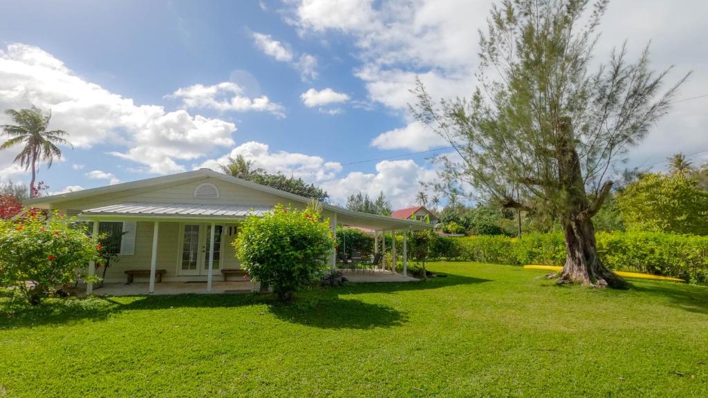 ein weißes Haus mit einem Baum im Hof in der Unterkunft Tavaetu Guesthouse - île de TUBUAI in Tubuai