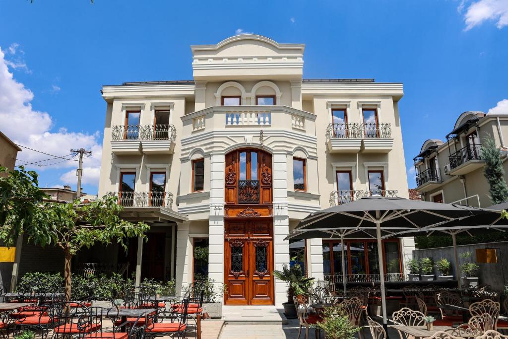 a building with tables and chairs in front of it at Vila Borgjeze in Korçë