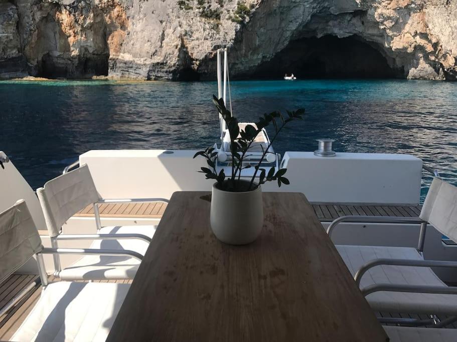 a table on a boat with a potted plant on it at Motor yacht 45' in Egina