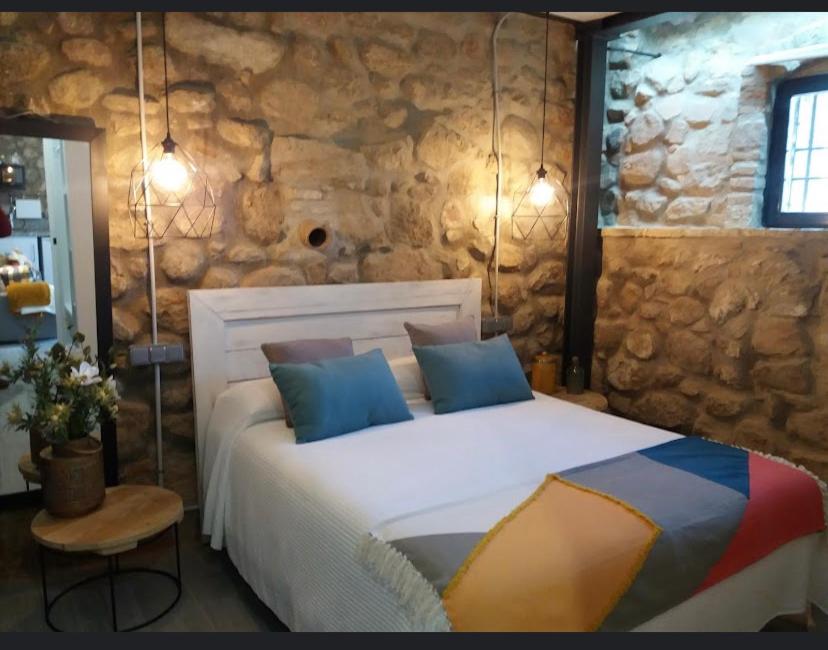 a bedroom with a large bed in a stone wall at La Bodega in Andújar