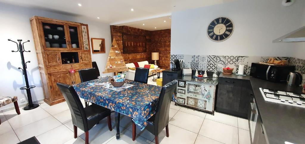 a kitchen with a table with chairs and a counter top at Gīte du café Truchet in Saint-Pancrace