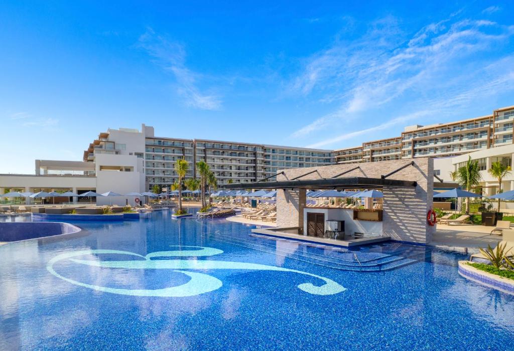 a large swimming pool in front of a hotel at Royalton Splash Riviera Cancun, An Autograph Collection All-Inclusive Resort in Cancún