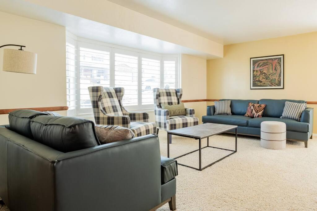 a living room with couches and chairs and a table at Spacious Stay near Airport, Downtown & Ski Resorts in North Salt Lake