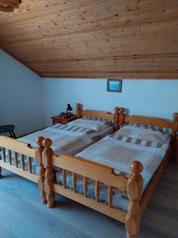 ein Holzbett in einem Zimmer mit Holzdecke in der Unterkunft APARTMA 27 in Kranjska Gora
