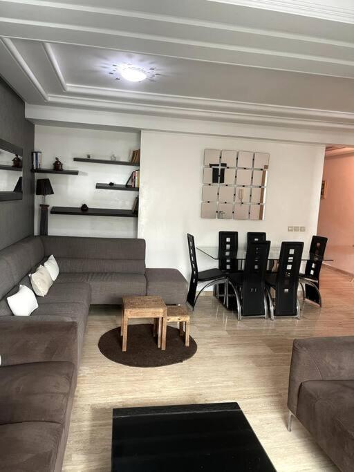 a living room with a couch and a table and chairs at Joli logement in Casablanca