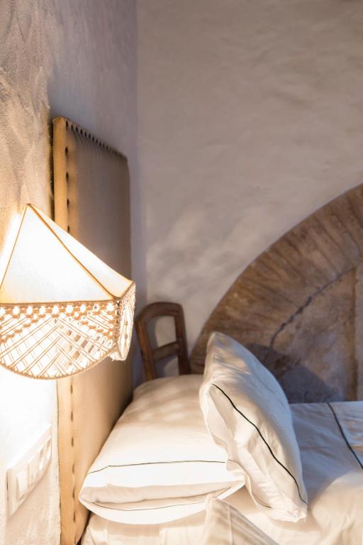 a bedroom with a bed and a lamp on a table at Hotel Tugasa Convento San Francisco in Vejer de la Frontera