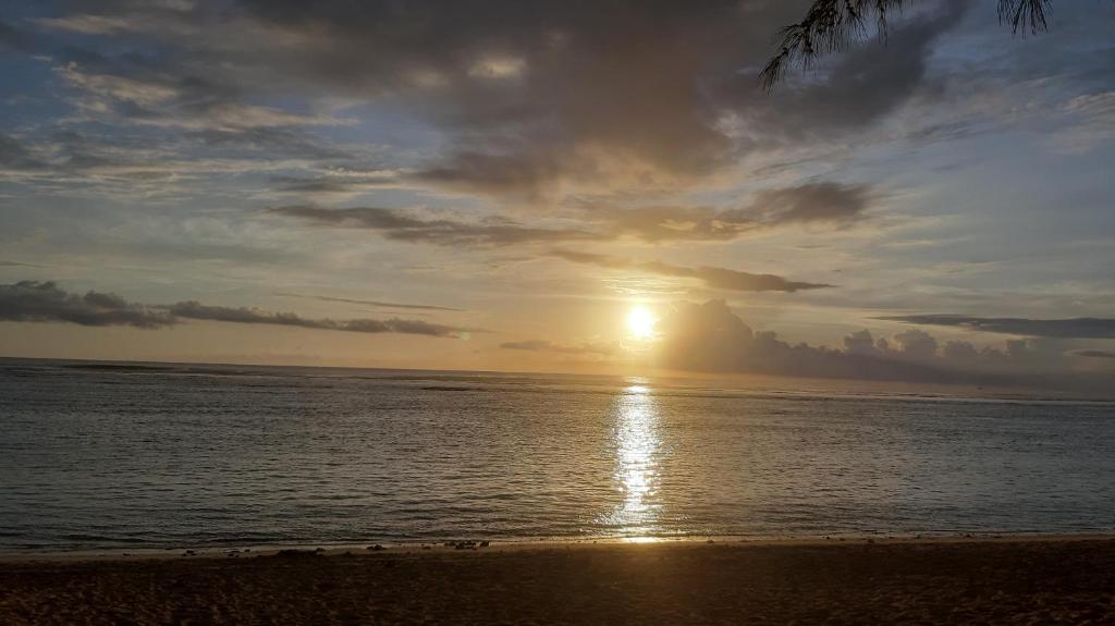 a sunset on the beach with the sun setting at Loarive in Saint-Gilles les Bains