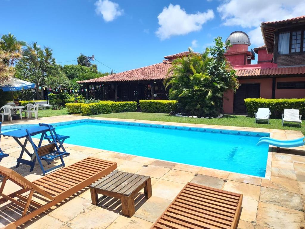 a swimming pool with chairs and a house at Numa Boa HOSTEL Búzios in Búzios