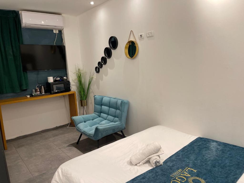 1 dormitorio con 1 cama y 1 silla azul en Elven Hotel, en Jerusalén