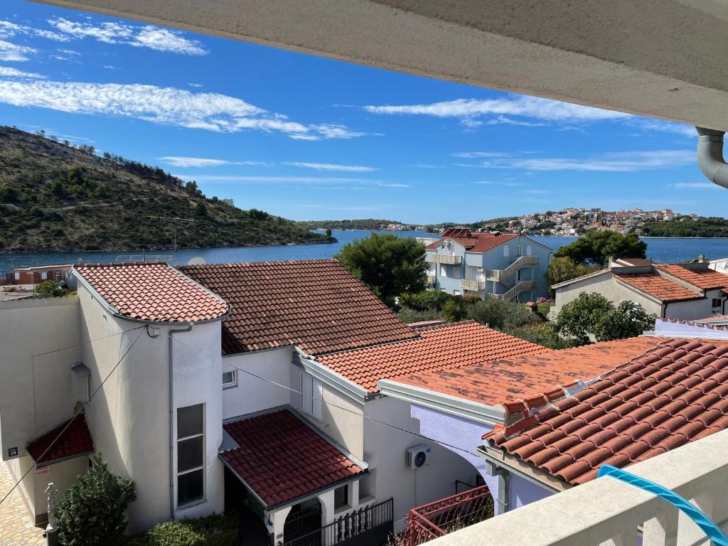 vistas al agua desde el balcón de un edificio en Apartments Edita, en Rogoznica