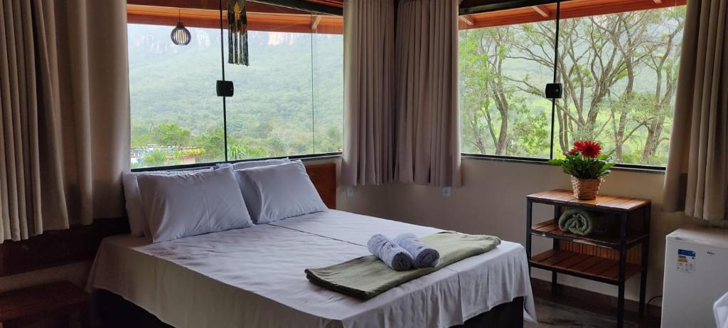 uma cama num quarto com uma janela com toalhas em Pousada Jipe Canastra em Capitólio