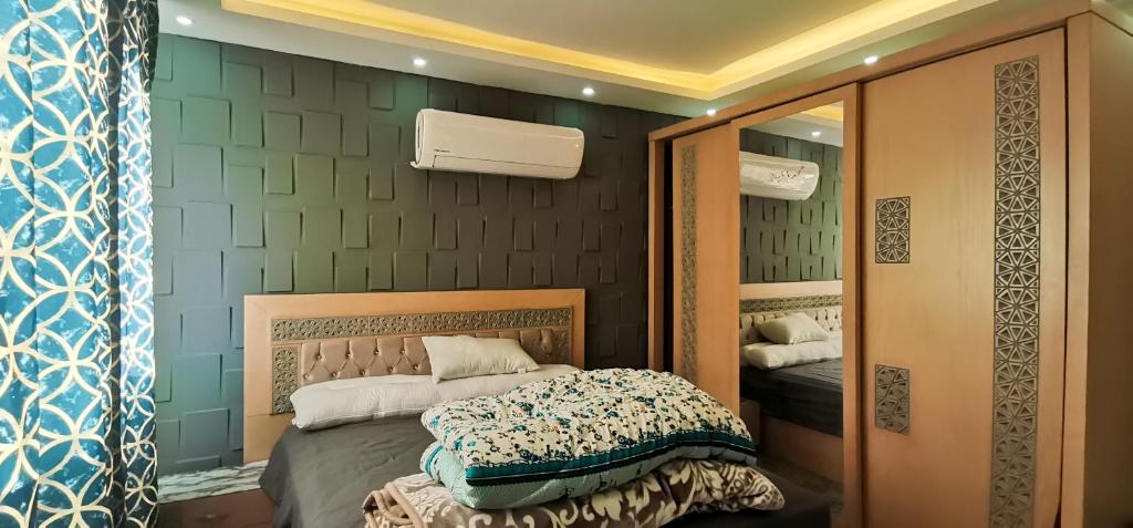 een slaapkamer met een bed en een spiegel bij shehab - residence Hotel apartment in Caïro