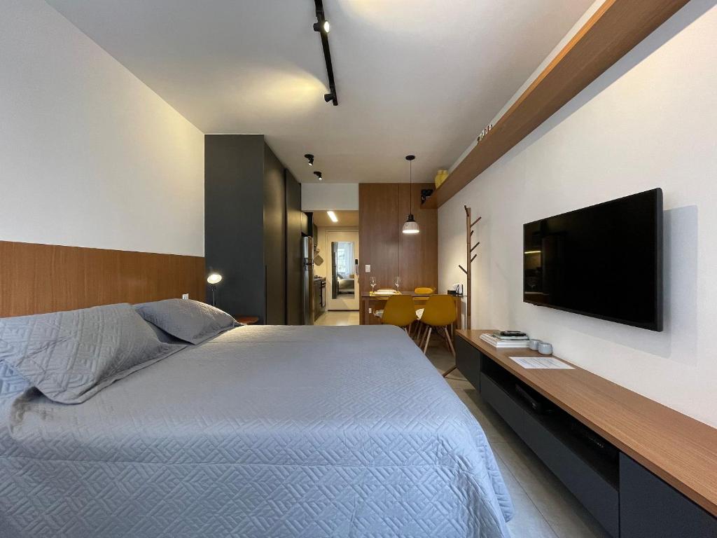 1 dormitorio con 1 cama grande y TV de pantalla plana en Conforto e praticidade próximo à Oscar Freire, en São Paulo