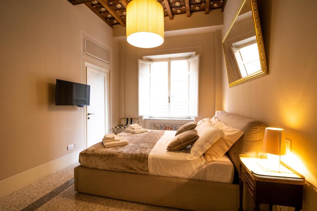 een slaapkamer met een bed en een raam bij Noble Floor - Luxury Apartments in Lucca