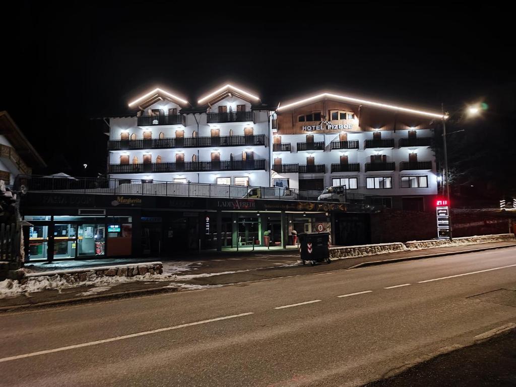 a large building with lights on the side of a road at Hotel Pizboè in Mazzin