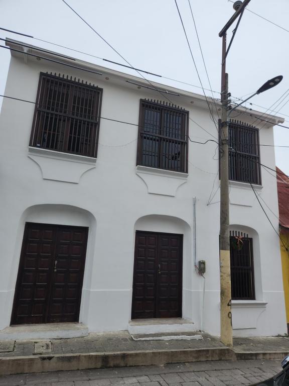 una casa blanca con dos puertas marrones en Hotel Casa de Don Francisco, en Flores