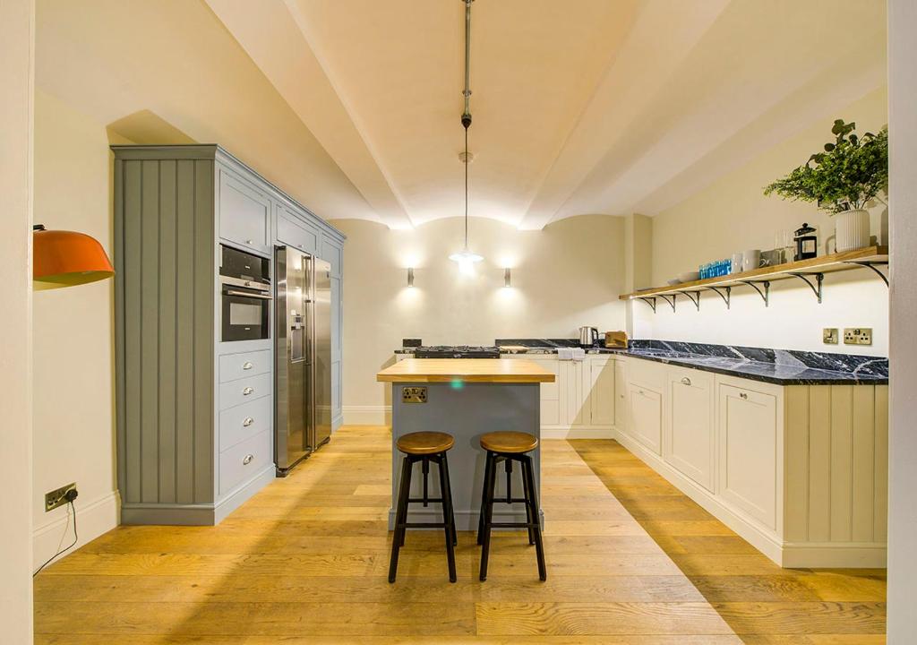 a kitchen with two bar stools at a counter at Super central Edinburgh Castle basement in Edinburgh