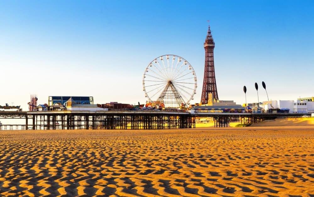 a sandy beach with a ferris wheel in the background at Regent Apartment 1 in Blackpool