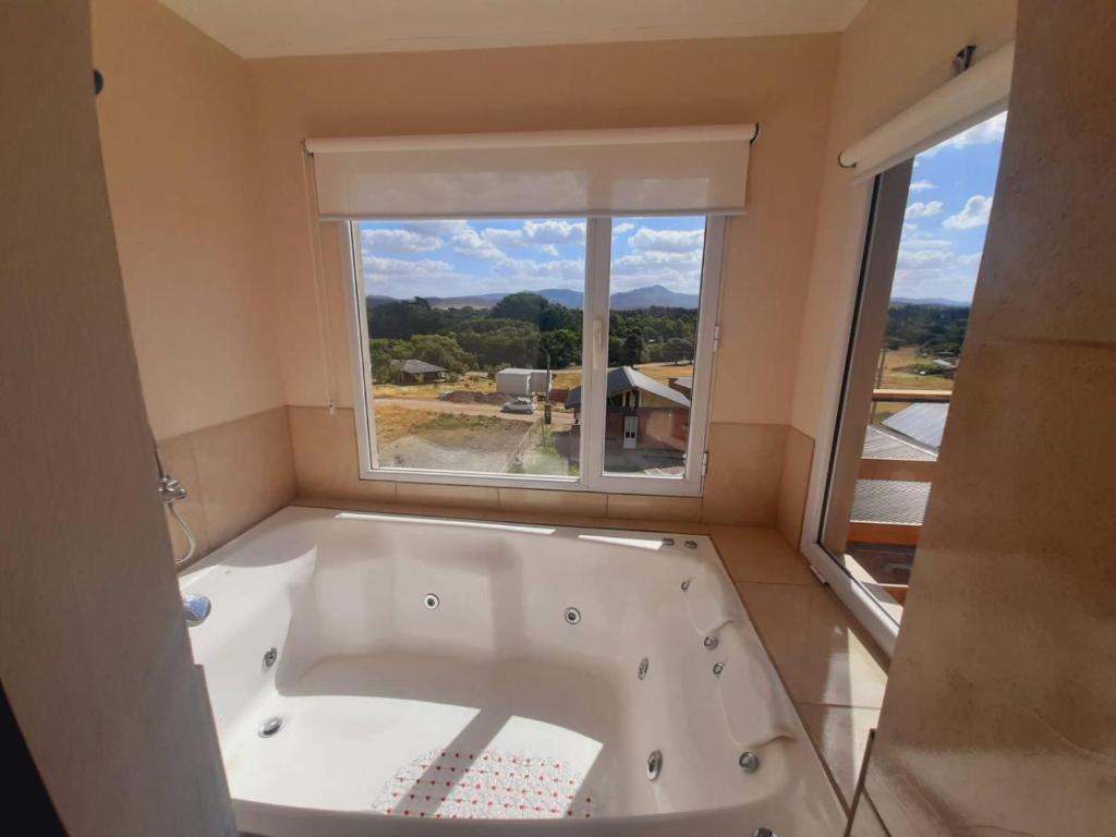 a bath tub in a bathroom with a window at Balcón del Cerro in Sierra de la Ventana