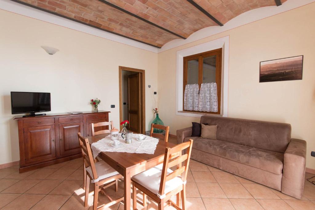 uma sala de estar com uma mesa e um sofá em Agriturismo Podere Camollia em Costalpino