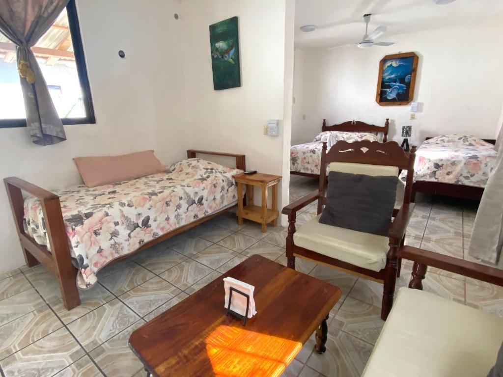 a bedroom with two beds and a table and chairs at Posada Xtakay Bacalar ''Turix'' in Bacalar