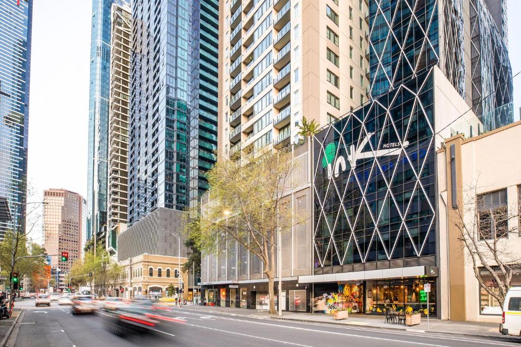 a busy city street with tall buildings and cars at Ink Hotel Melbourne Southbank in Melbourne