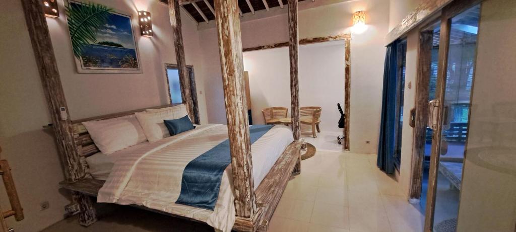 a bedroom with a four poster bed with a mirror at Oasis Villas in Gili Trawangan