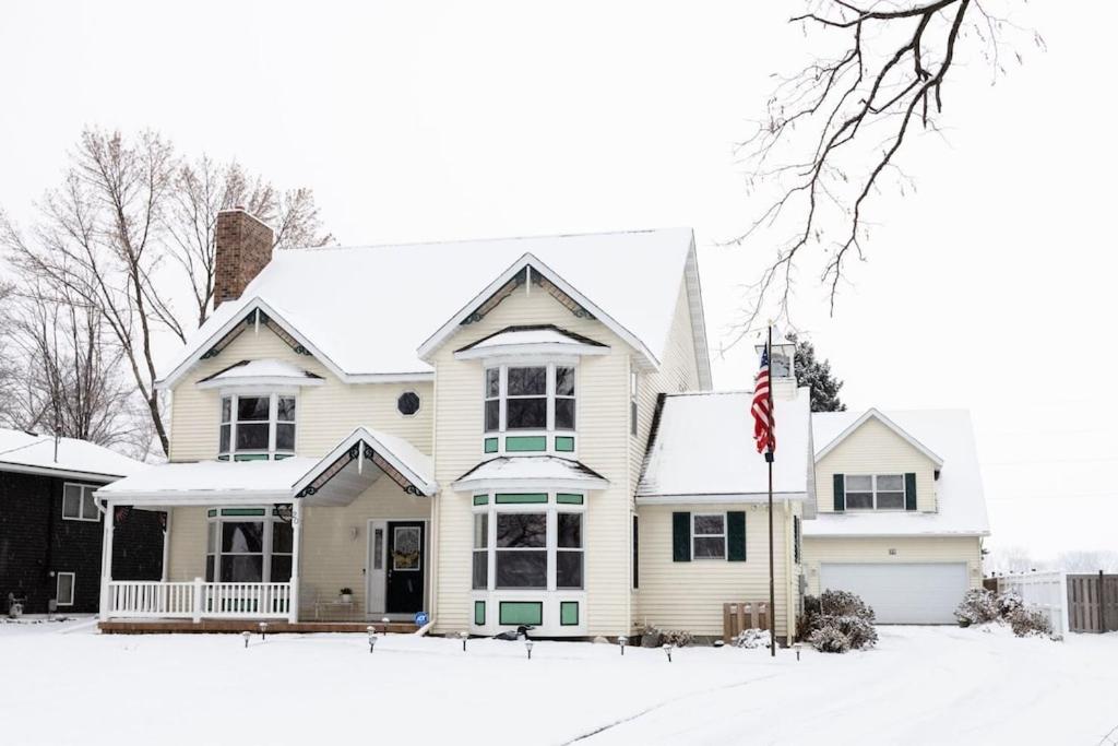 uma casa branca com uma bandeira na neve em Bell House on Madison Lake em Elysian