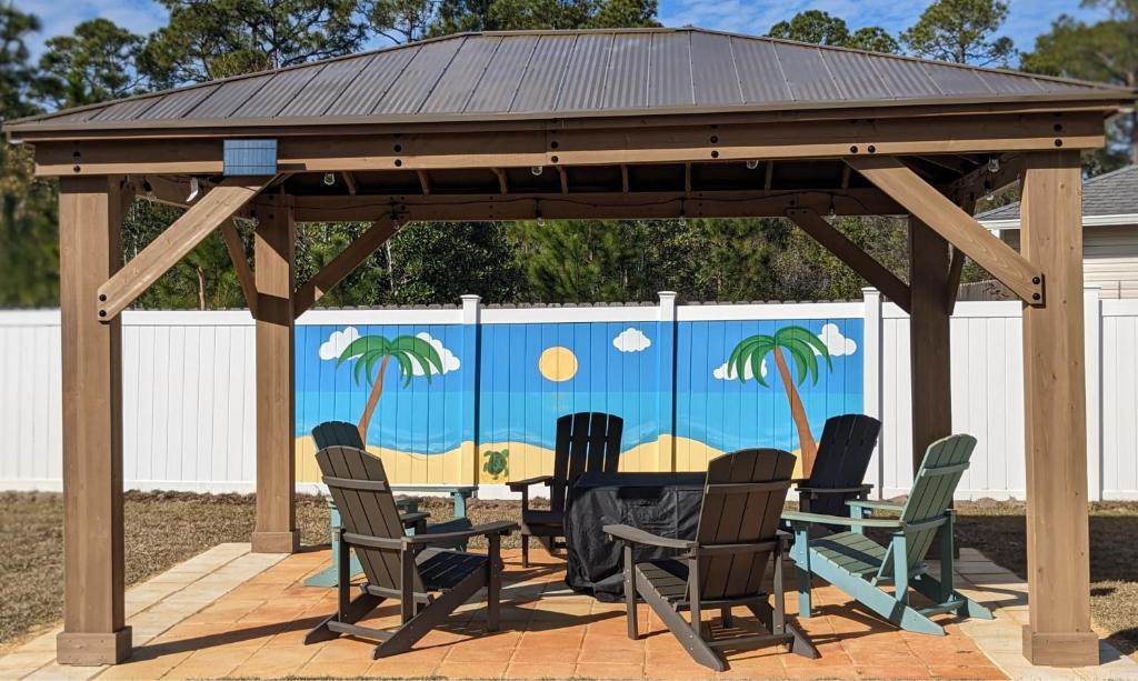 einen hölzernen Pavillon mit Stühlen und einem Tisch auf der Terrasse in der Unterkunft Beachy Bliss the perfect stay in Navarre