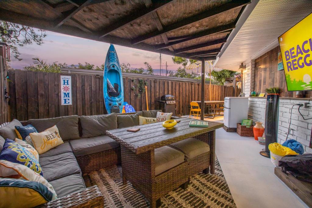 a patio with a couch and a table and a surfboard at La Mia Casa in Sarasota