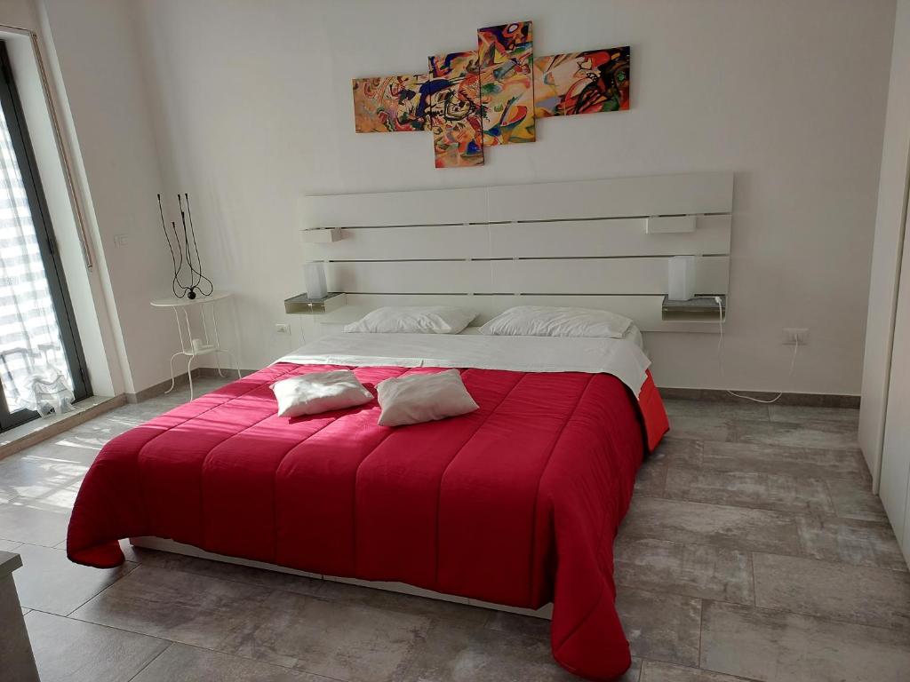 una camera con un letto rosso con due cuscini sopra di Pierpa's House o Casa Pierpa a Catania