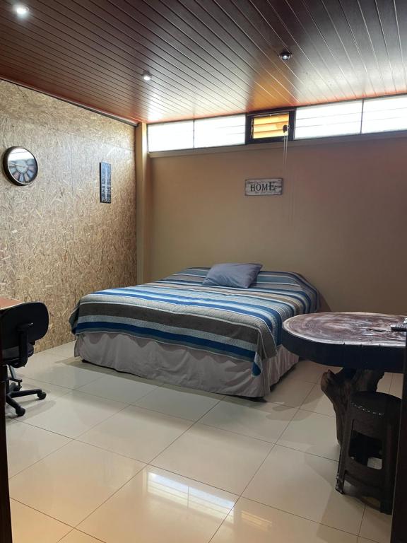 Un dormitorio con una cama y una mesa. en HuehueLoft1 estacionamiento y wifi, en Huehuetenango