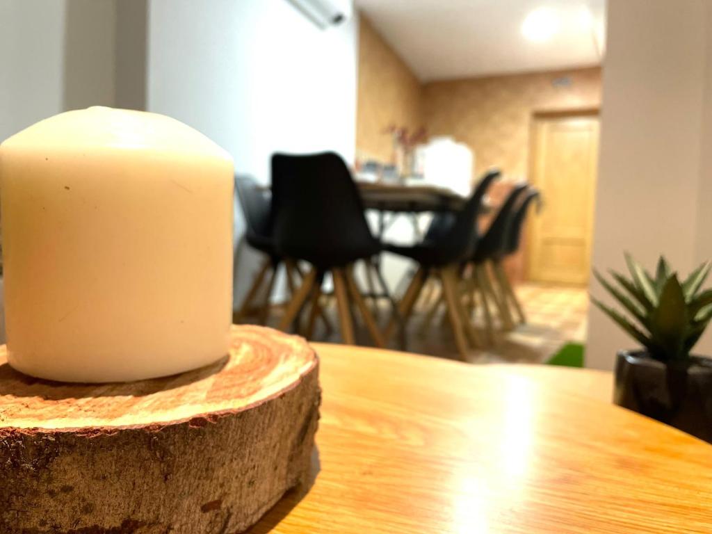 świeca siedząca na drewnianym stole w obiekcie Alojamiento Retama Toledo w mieście Toledo