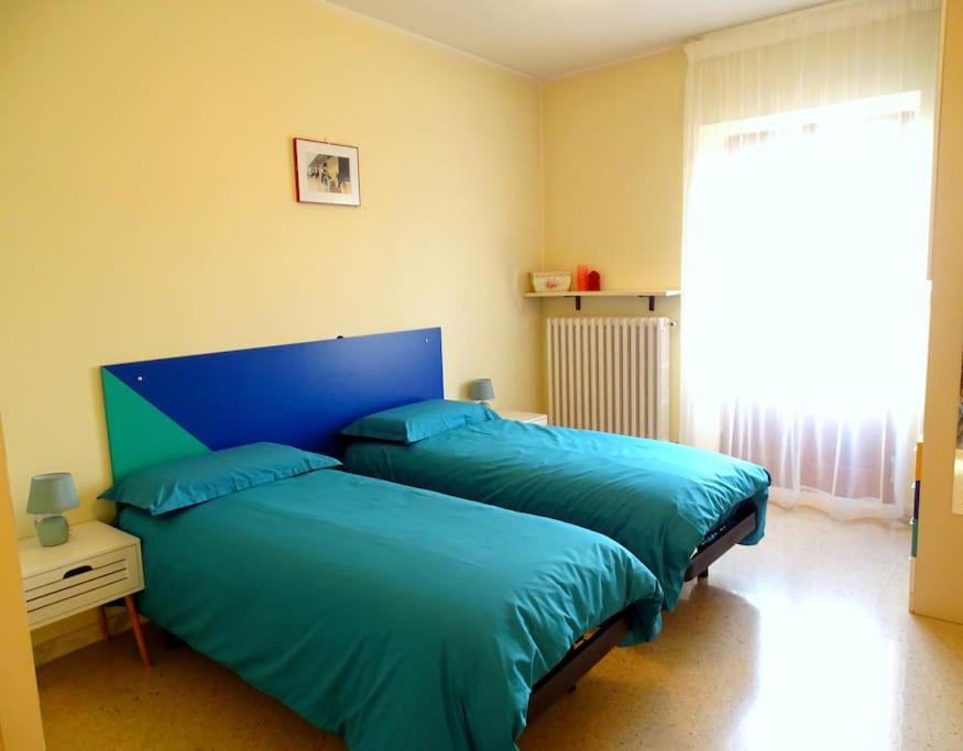 1 dormitorio con 2 camas azules y ventana en Casa Fontanelle en Celano