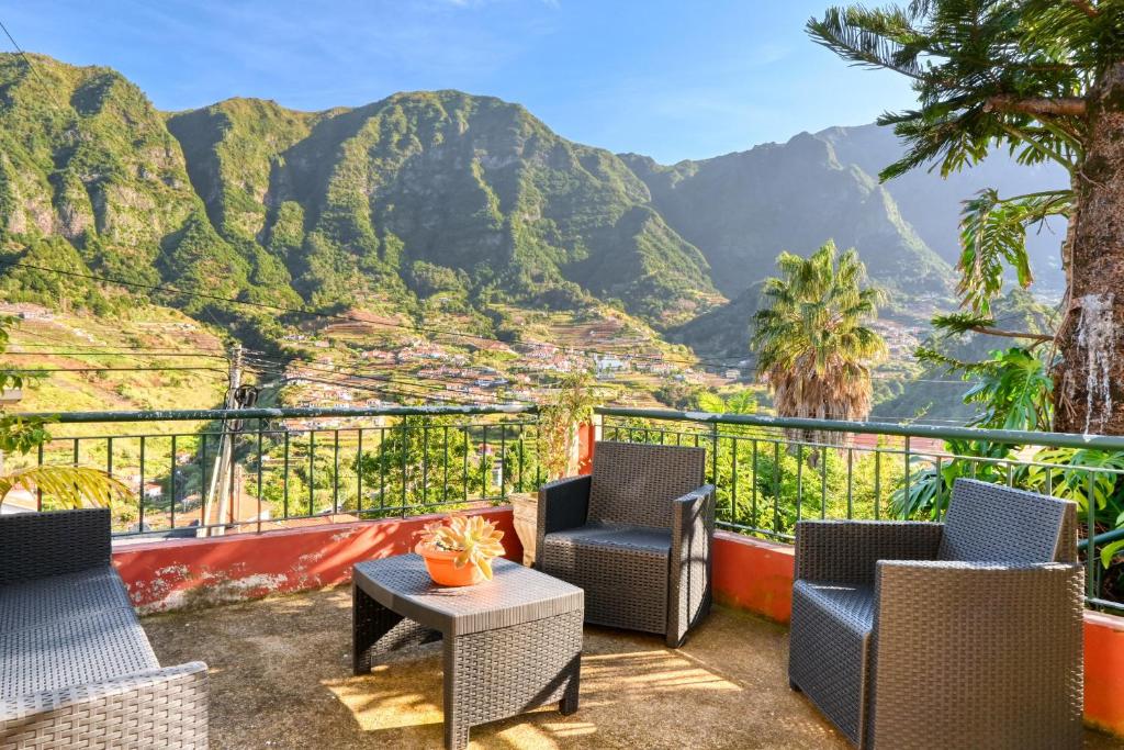 a balcony with chairs and a view of mountains at Casa do Pinheiro, a Home in Madeira in São Vicente