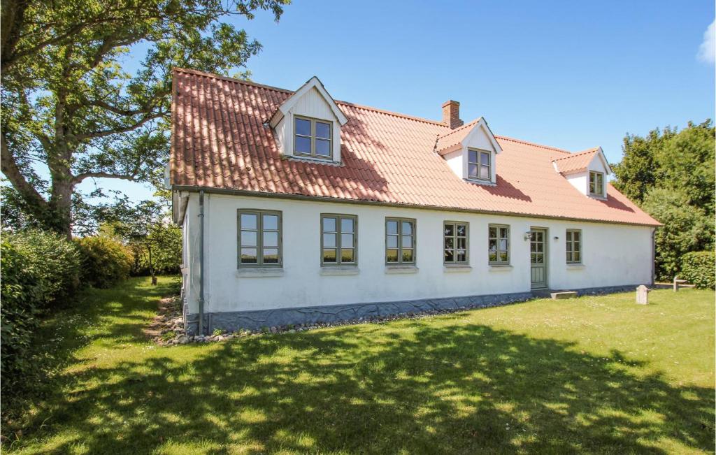 a white house with a red roof on a yard at 4 Bedroom Stunning Home In Sams in Brundby