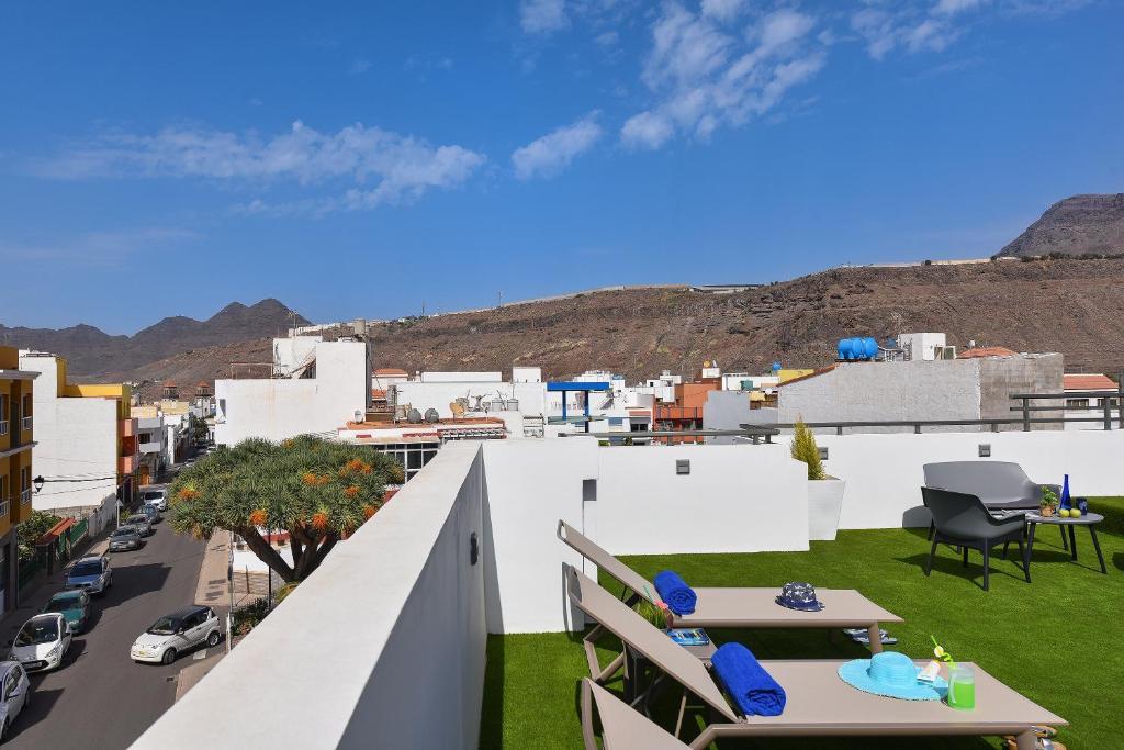 a balcony with tables and chairs and a city at Apartamento Starlight La Aldea I in San Nicolás