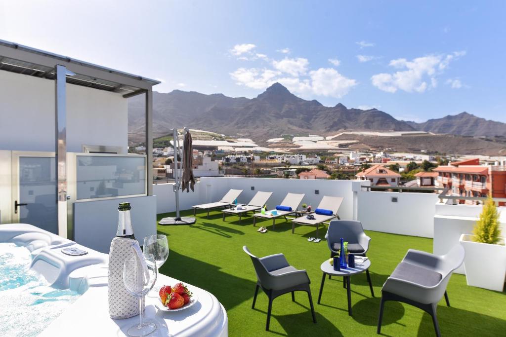 a rendering of a rooftop patio with chairs and tables at Apartamento Starlight La Aldea I in San Nicolás