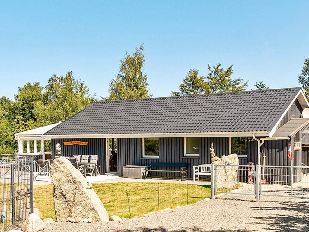 ein Haus mit einem Zaun davor in der Unterkunft 10 person holiday home in Fårevejle-By Traum in Fårevejle