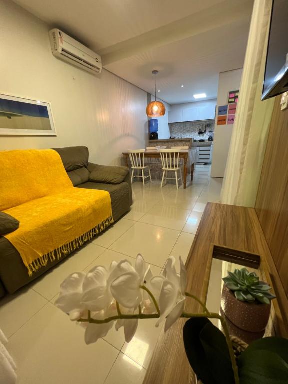 a living room with a yellow couch and a table at Casa em Condomínio agradável com fundo pro rio in Barreirinhas