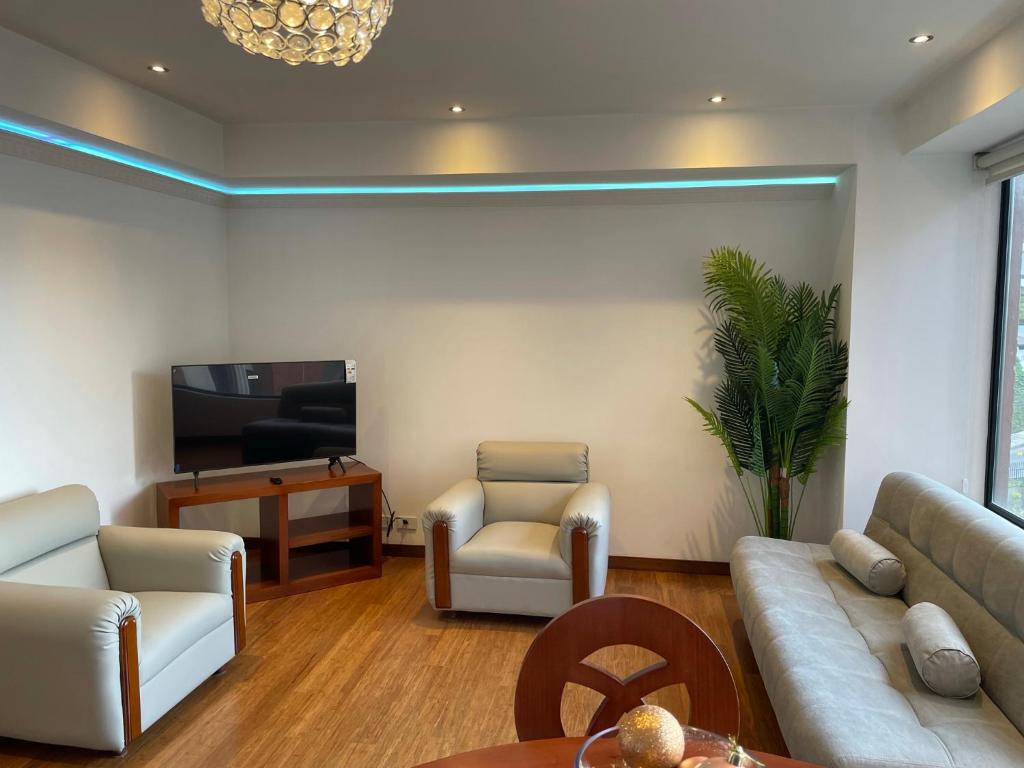 sala de estar con sofá, sillas y TV en Apartamento Quito tenis, en Quito