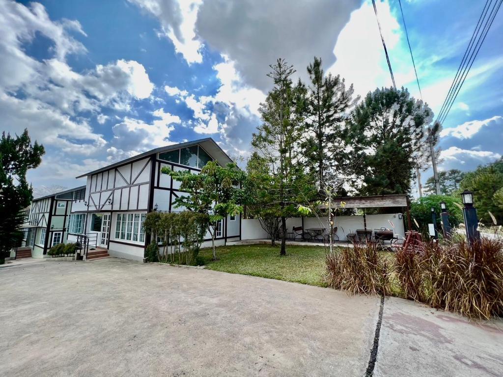 a large white house with a lot of windows at The Beaf Home Khaokho in Khao Kho