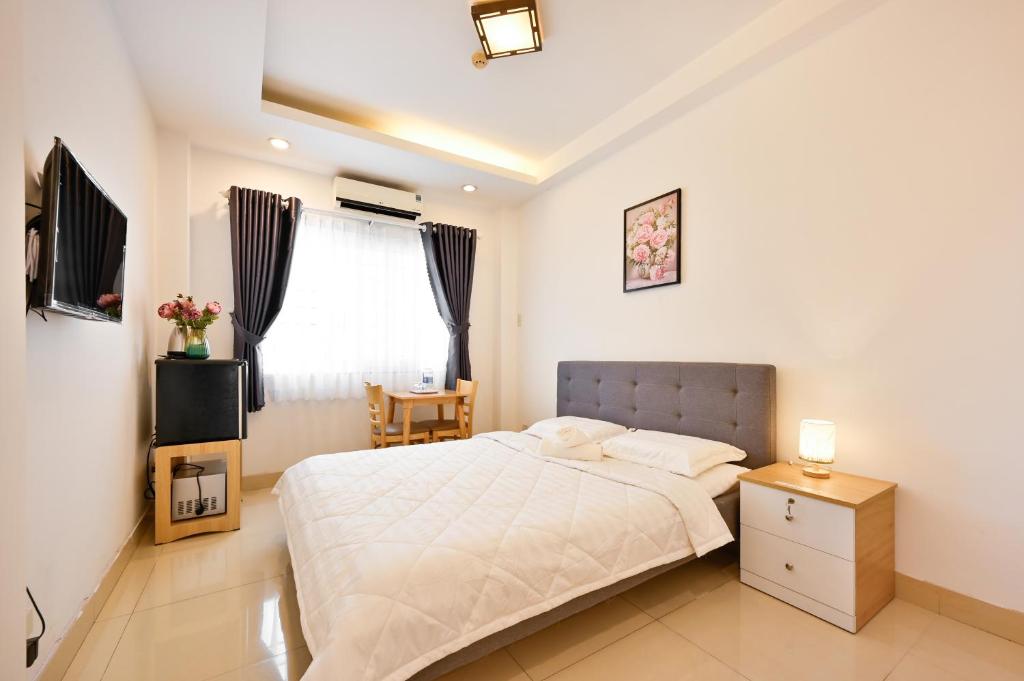 a bedroom with a bed and a table and a window at Huyen Homestay in Ho Chi Minh City