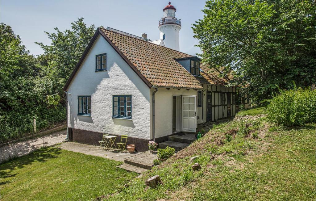 ein kleines Haus mit einem Leuchtturm darüber in der Unterkunft Fyrassistentens in Kolby Kås