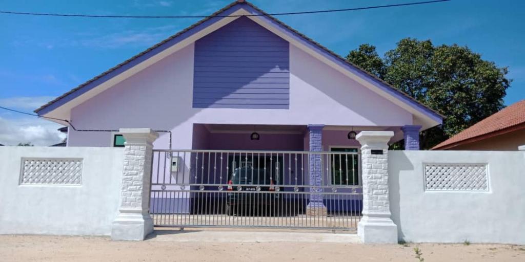 une maison avec un portail et une clôture dans l'établissement PCB PURPLE GUEST HOUSE, à Kota Bharu
