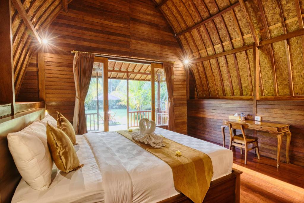 a bedroom with a bed in a wooden room at Puri Yalus Bungalow in Nusa Penida