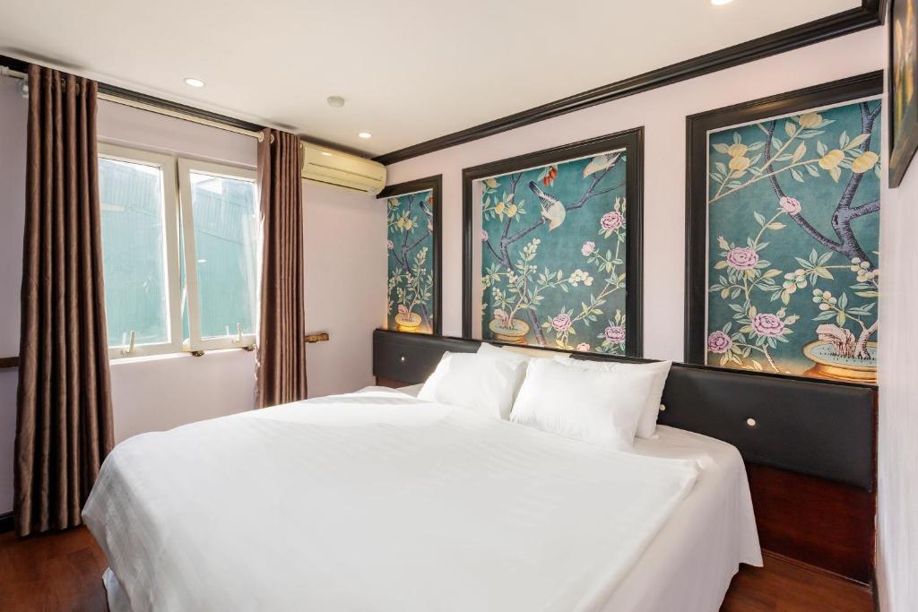 Hanoi Memory Premier Hotel & Spa في هانوي: غرفة نوم بسرير ابيض ونوافذ