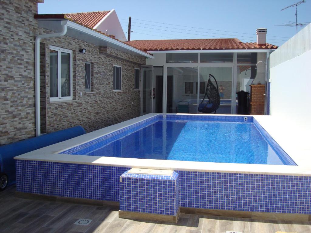una piscina rodeada de azulejos azules y blancos. en Villa T4 35km Montargil - Private & Heated Pool en Casal do Anafe de Baixo